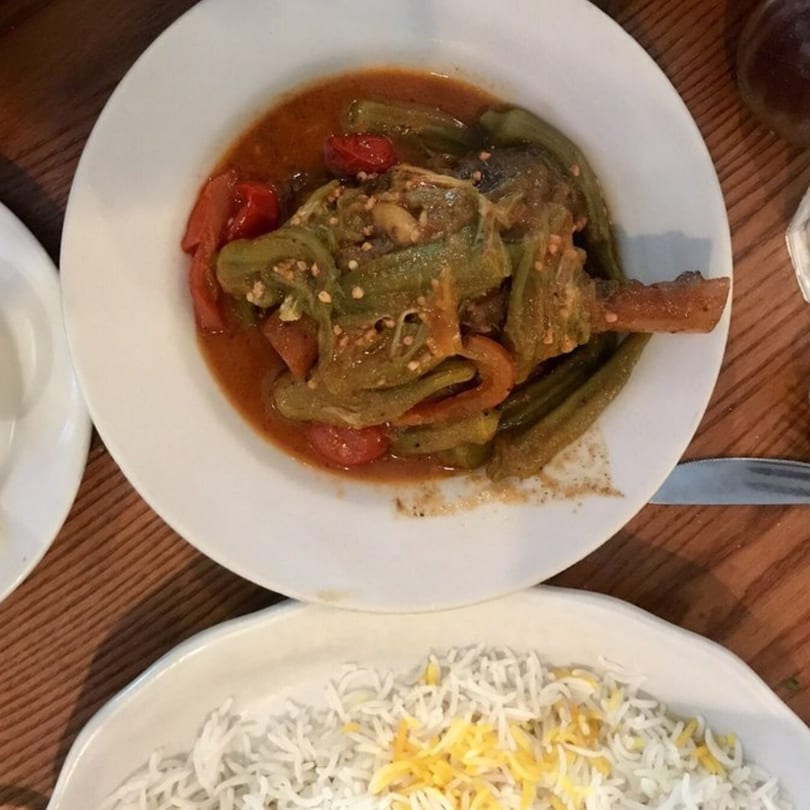 A Persian dish with stewed okra and tomatoes in a rich sauce, served with white rice.